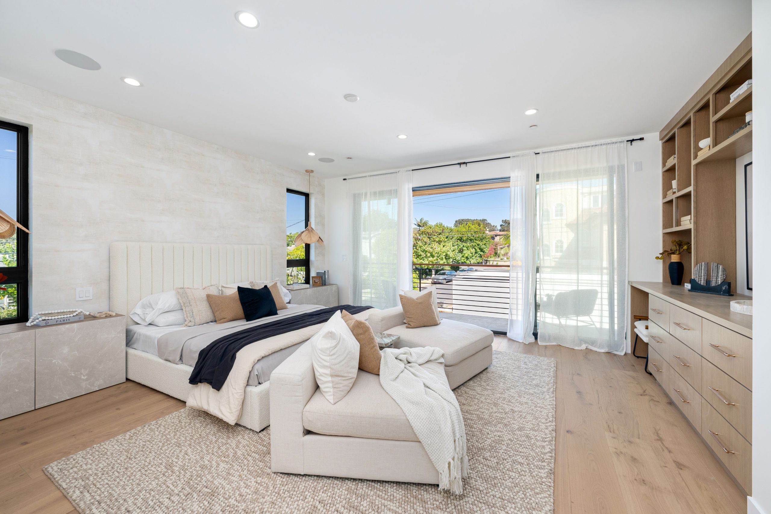 A serene primary bedroom with an open balcony view, designed by Chi's Nest